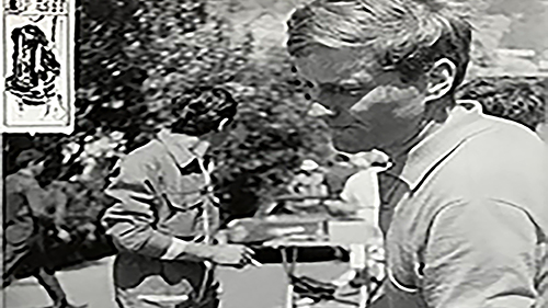 Schwarz-Weiß-Aufnahme: Johannes Ortner im Profil, im Hintergrund Zuschauer an einer Rennstrecke