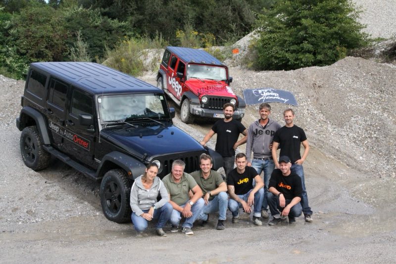 Die Mannschaft von Auto Ortner vor zwei Jeep Wrangler in einer Schottergrube bei einem Geländetraining