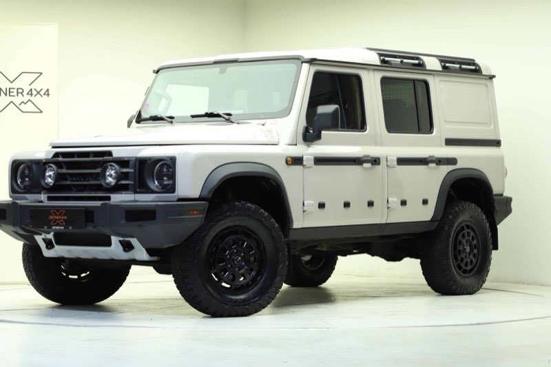 Ein von Ortner 4x4 umgebauter INEOS Grenadier in Weiß mit Dachträger, Geländerädern und verstärkter Frontstoßstange